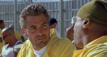 Movie still from “Out of Sight” (1998), directed by Steven Soderbergh – A man in a yellow jacket is looking to his left; Close Up shot, Over the shoulder angle