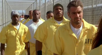 Movie still from “Out of Sight” (1998), directed by Steven Soderbergh – A large group of men in yellow prison uniforms; Medium shot, Low angle