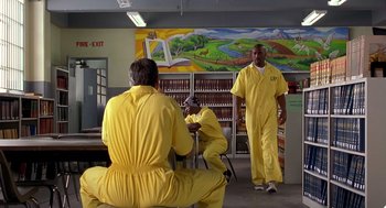 Movie still from “Out of Sight” (1998), directed by Steven Soderbergh – A group of men in yellow jumpsuits in a room; Wide shot, High angle
