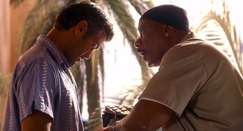 Movie still from “Out of Sight” (1998), directed by Steven Soderbergh – Two men talking to each other near a palm tree; Close Up shot, Low angle
