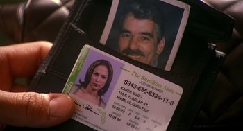Movie still from “Out of Sight” (1998), directed by Steven Soderbergh – A person holding a photo of a man in a wallet; Extreme Close Up shot, High angle