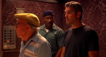 Movie still from “Out of Sight” (1998), directed by Steven Soderbergh – A group of men standing next to each other in an elevator; Medium shot, Low angle