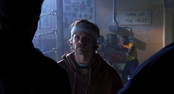 Movie still from “Out of Sight” (1998), directed by Steven Soderbergh – A man with a headband is standing in a room; Close Up shot, Over the shoulder angle