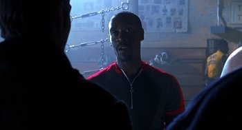Movie still from “Out of Sight” (1998), directed by Steven Soderbergh – A black man in a red and black jacket is talking to someone; Close Up shot, Over the shoulder angle