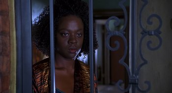 Movie still from “Out of Sight” (1998), directed by Steven Soderbergh – A woman standing behind bars in a dark room; Close Up shot, Over the shoulder angle