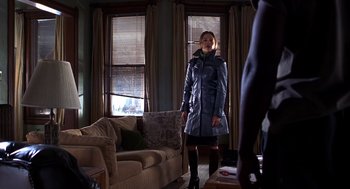 Movie still from “Out of Sight” (1998), directed by Steven Soderbergh – A woman standing in front of a man in front of a couch; Wide shot, Low angle