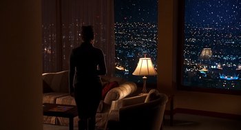 Movie still from “Out of Sight” (1998), directed by Steven Soderbergh – A woman standing in front of a window at night; Extreme Wide shot, High angle