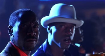 Movie still from “Out of Sight” (1998), directed by Steven Soderbergh – Two men are standing in front of a microphone; Close Up shot, Low angle