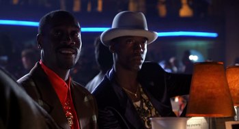 Movie still from “Out of Sight” (1998), directed by Steven Soderbergh – A couple of men sitting next to each other at a party; Close Up shot, Low angle