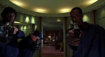 Movie still from “Out of Sight” (1998), directed by Steven Soderbergh – Two men are holding guns in a room; Medium shot, Low angle