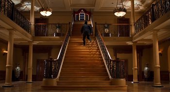 Movie still from “Out of Sight” (1998), directed by Steven Soderbergh – A man walking up a set of wooden stairs; Wide shot, Low angle