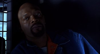 Movie still from “Out of Sight” (1998), directed by Steven Soderbergh – A man with a beard is looking at the camera; Close Up shot, High angle