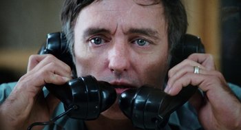 Movie still from “Out of the Blue” (1980), directed by Dennis Hopper – A person holding a phone up to their face; Close Up shot, Low angle