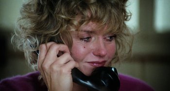 Movie still from “Out of the Blue” (1980), directed by Dennis Hopper – A person talking on a phone; Close Up shot, High angle
