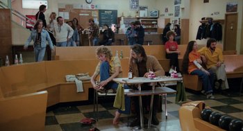 Movie still from “Out of the Blue” (1980), directed by Dennis Hopper – A man and a woman sitting at a table in a restaurant; Wide shot, High angle