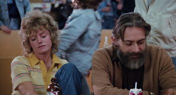 Movie still from “Out of the Blue” (1980), directed by Dennis Hopper – A man and a woman sitting at a table with drinks; Medium shot, Low angle