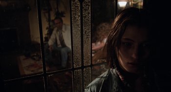 Movie still from “Out of the Blue” (1980), directed by Dennis Hopper – A woman standing behind bars in front of a man; Close Up shot, Over the shoulder angle