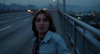Movie still from “Out of the Blue” (1980), directed by Dennis Hopper – A woman standing next to a bridge at night; Close Up shot, High angle