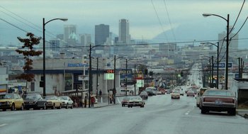Movie still from “Out of the Blue” (1980), directed by Dennis Hopper – A city street filled with lots of traffic and buildings; Extreme Wide shot, High angle