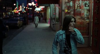 Movie still from “Out of the Blue” (1980), directed by Dennis Hopper – A woman walking down a street at night; Medium shot, Over the shoulder angle