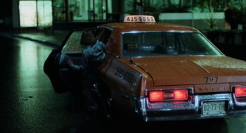 Movie still from “Out of the Blue” (1980), directed by Dennis Hopper – A taxi cab parked on the side of the road at night; Wide shot, Low angle