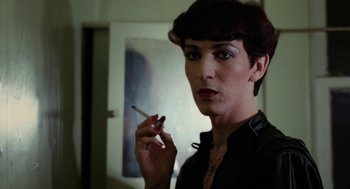 Movie still from “Out of the Blue” (1980), directed by Dennis Hopper – A person holding a cigarette in a room; Close Up shot, Over the shoulder angle