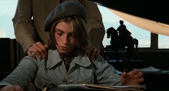 Movie still from “Out of the Blue” (1980), directed by Dennis Hopper – A woman sitting at a table with a book in front of her face; Close Up shot, High angle