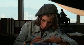 Movie still from “Out of the Blue” (1980), directed by Dennis Hopper – A person sitting at a table writing on a piece of paper; Medium shot, High angle