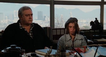 Movie still from “Out of the Blue” (1980), directed by Dennis Hopper – A man and a woman sitting in front of a window; Medium shot, Over the shoulder angle