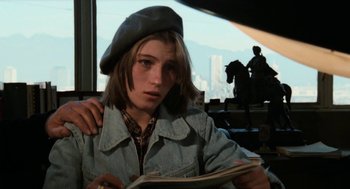 Movie still from “Out of the Blue” (1980), directed by Dennis Hopper – A woman in a denim jacket reading a magazine; Close Up shot, High angle