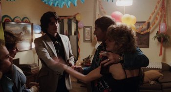 Movie still from “Out of the Blue” (1980), directed by Dennis Hopper – A man and a woman shaking hands with another man in a suit; Medium shot, Over the shoulder angle