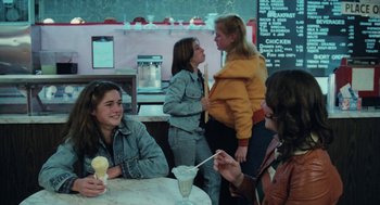 Movie still from “Out of the Blue” (1980), directed by Dennis Hopper – A group of young women sitting at a table with ice cream; Medium shot, High angle