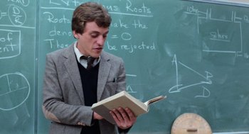 Movie still from “Out of the Blue” (1980), directed by Dennis Hopper – A young man reading a book in front of a chalkboard; Medium shot, Low angle