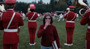 Movie still from “Out of the Blue” (1980), directed by Dennis Hopper – A group of people in a field playing a band; Medium shot, Low angle