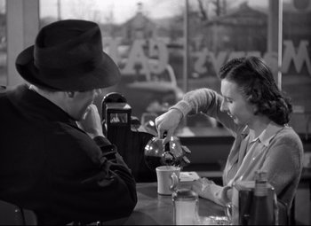 Movie still from “Out of the Past” (1947), directed by Jacques Tourneur – A woman pouring a cup of tea into a man's hand; Medium shot, High angle