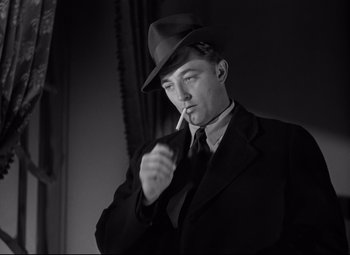 Movie still from “Out of the Past” (1947), directed by Jacques Tourneur – A black and white photo of a man smoking a cigarette; Close Up shot, Low angle