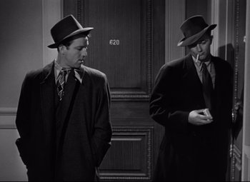 Movie still from “Out of the Past” (1947), directed by Jacques Tourneur – A couple of men standing next to each other in a room; Medium shot, Low angle