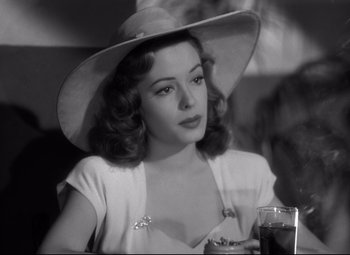 Movie still from “Out of the Past” (1947), directed by Jacques Tourneur – A black and white photo of a woman in a hat; Close Up shot, Over the shoulder angle
