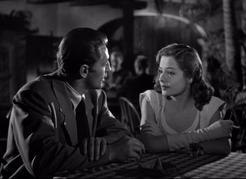 Movie still from “Out of the Past” (1947), directed by Jacques Tourneur – A man and a woman sitting at a table talking to each other; Medium shot, Over the shoulder angle