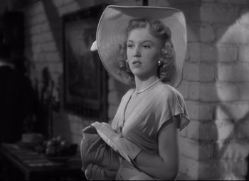 Movie still from “Out of the Past” (1947), directed by Jacques Tourneur – A black and white photo of a woman wearing a hat; Close Up shot, Low angle