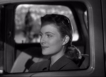 Movie still from “Out of the Past” (1947), directed by Jacques Tourneur – A black and white photo of a woman in the back of a car; Close Up shot, Over the shoulder angle