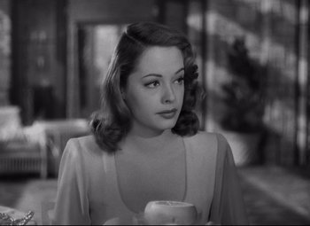 Movie still from “Out of the Past” (1947), directed by Jacques Tourneur – A black - and - white photo of a woman with a cup; Close Up shot, Over the shoulder angle