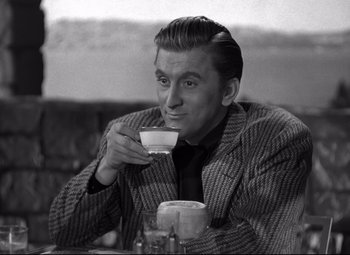 Movie still from “Out of the Past” (1947), directed by Jacques Tourneur – A man sitting at a table drinking a cup of coffee; Medium shot, High angle