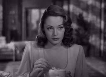 Movie still from “Out of the Past” (1947), directed by Jacques Tourneur – A black - and - white photo of a woman holding a candle; Close Up shot, High angle