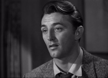 Movie still from “Out of the Past” (1947), directed by Jacques Tourneur – Black and white photograph of a man in a suit; Close Up shot, Over the shoulder angle
