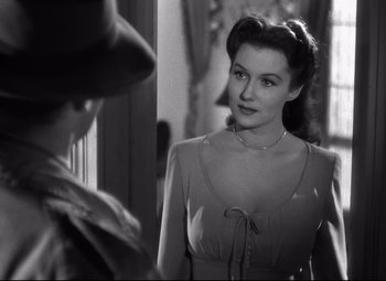 Movie still from “Out of the Past” (1947), directed by Jacques Tourneur – A black - and - white photo of a woman looking at a man; Close Up shot, Over the shoulder angle