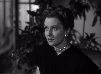Movie still from “Out of the Past” (1947), directed by Jacques Tourneur – A woman in a black dress with a necklace; Close Up shot, Low angle