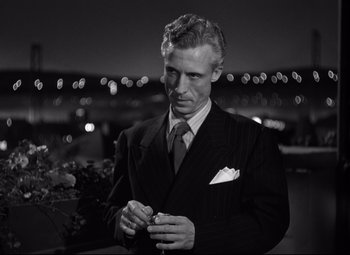 Movie still from “Out of the Past” (1947), directed by Jacques Tourneur – A black and white photo of a man in a suit and tie; Close Up shot, Low angle
