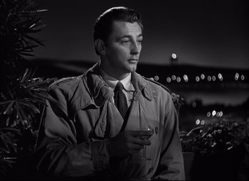 Movie still from “Out of the Past” (1947), directed by Jacques Tourneur – A black and white photo of a man smoking a cigarette; Medium shot, Over the shoulder angle