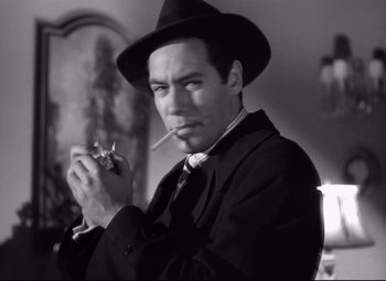 Movie still from “Out of the Past” (1947), directed by Jacques Tourneur – A black and white photo of a man smoking a cigarette; Close Up shot, Low angle